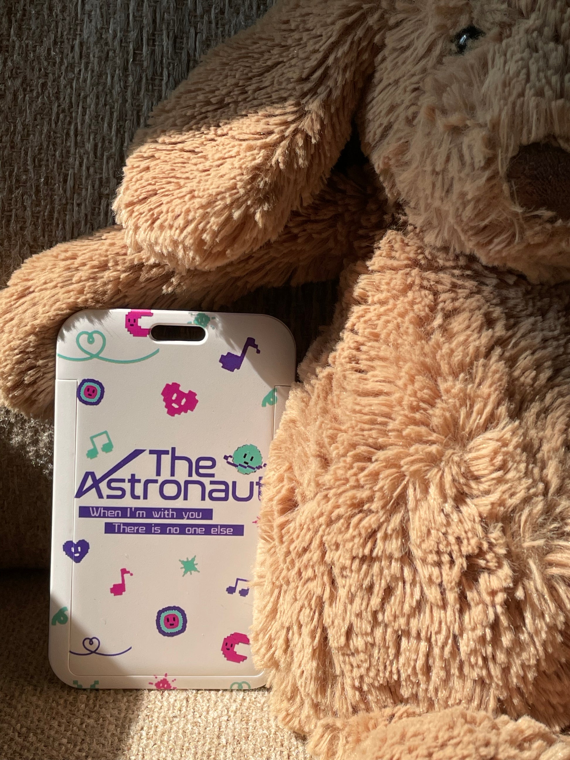 a teddy bear is holding a cell phone 